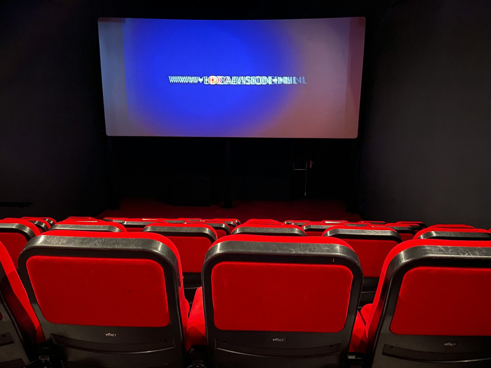 israelagent.com a theater with red seats and a projector screen